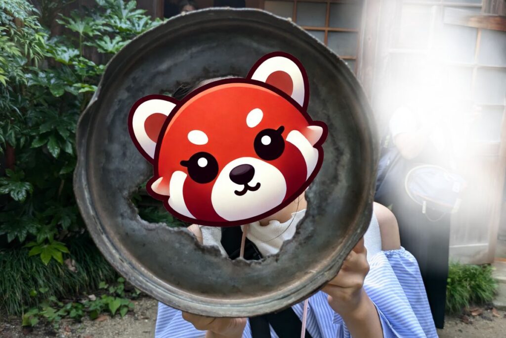 A playful recreation of a Totoro scene with a child peeking through a broken bucket at Satsuki and Mei's house in Ghibli Park