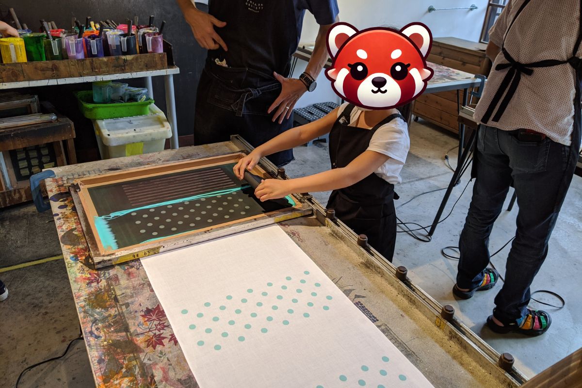 Child enjoying traditional tenugui dyeing in Gujo Hachiman — a fun hands-on activity during your family trip to Japan.