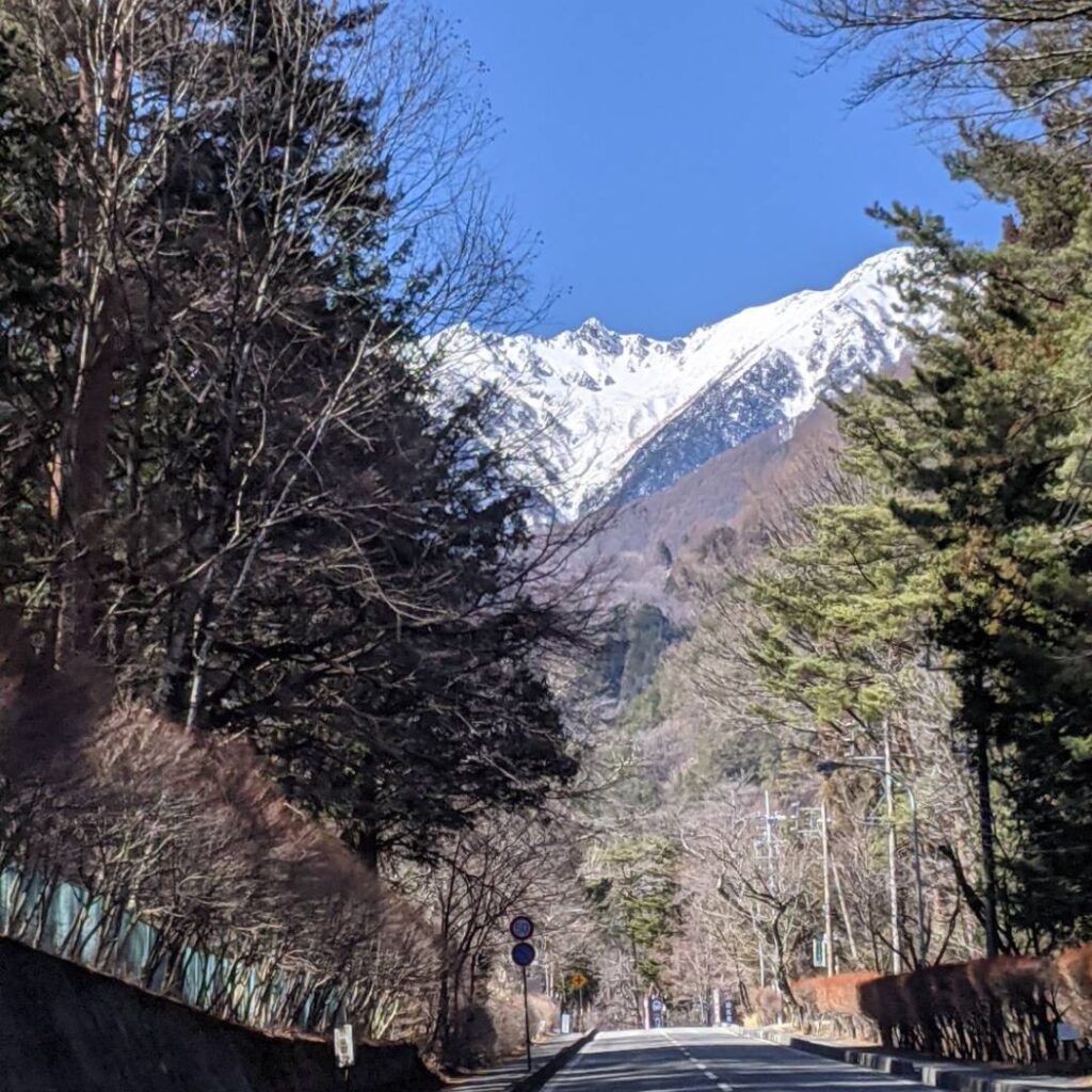 Driving toward the Central Alps Japan with snow-capped peaks ahead – a scenic road trip on your Nagano Japan travel.