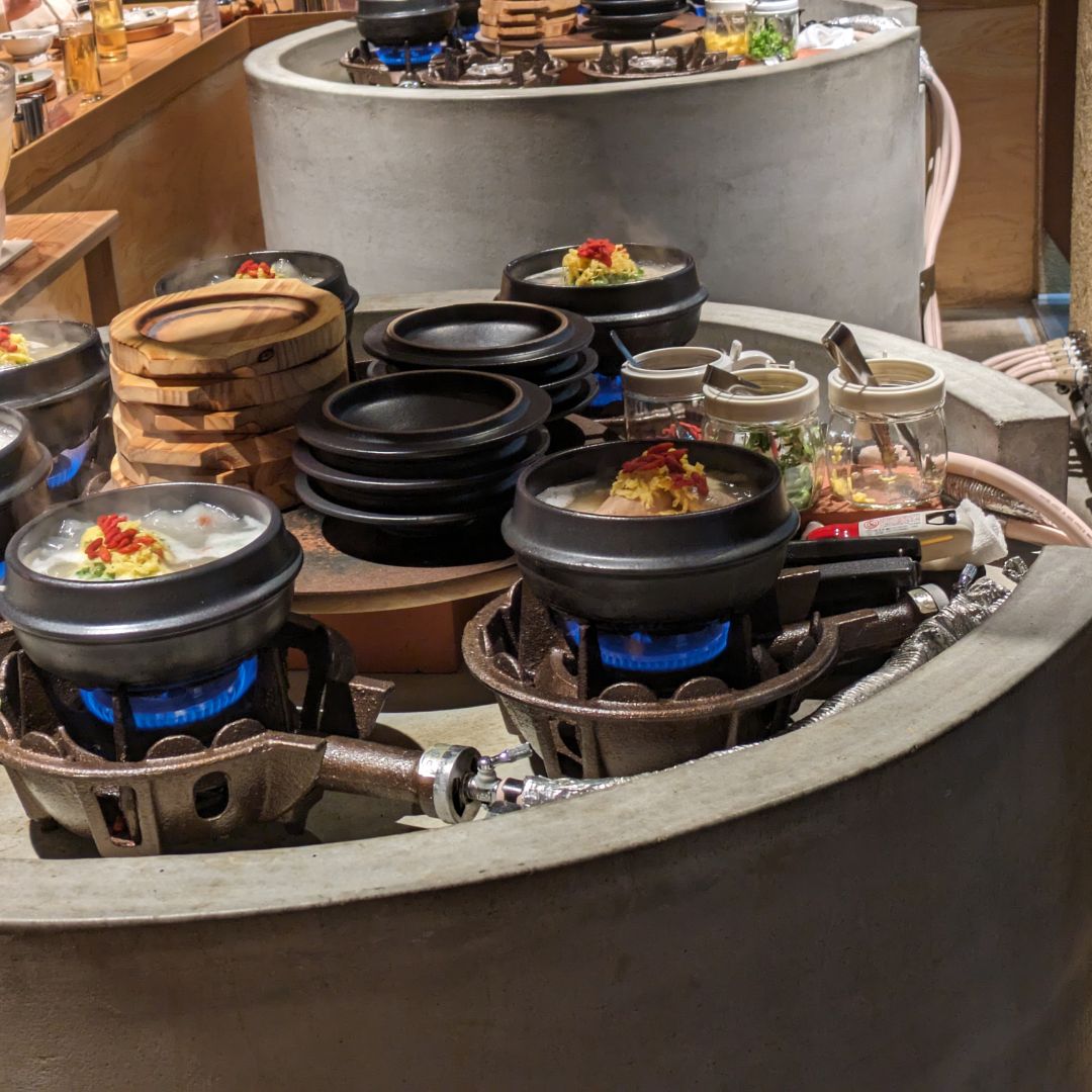 Korean hot pot dishes cooking at a restaurant in Tsuruhashi, Osaka – explore unique Osaka day trips from Kyoto.