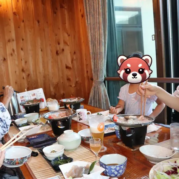 Family enjoying a traditional Japanese dinner at a wooden dining room in Takamine Onsen.