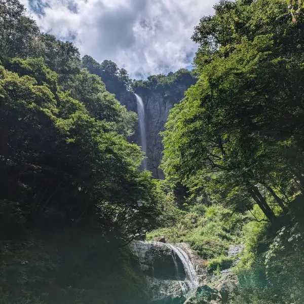 Looking up at Fudō Falls during a Nagano waterfall hike in summer.