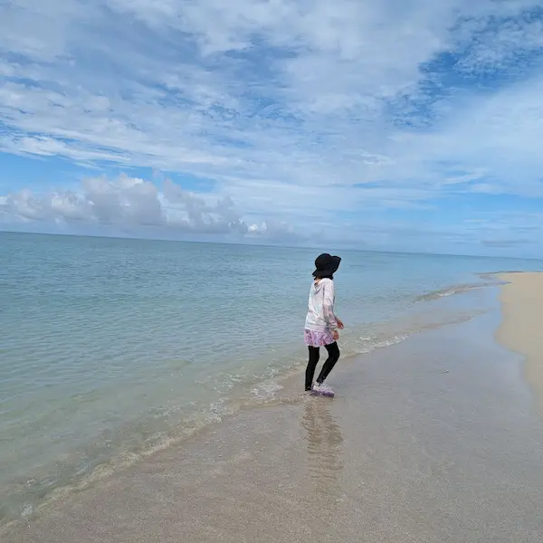 Child walking along the shore in Okinawa’s Miyako Island, a peaceful moment on an Okinawa itinerary.