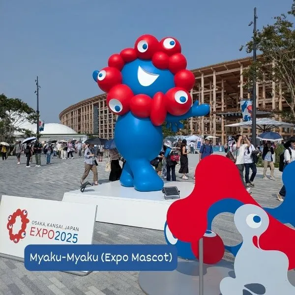 Myaku-Myaku, the official Expo 2025 Osaka mascot, greeting families at the entrance of the Expo site.