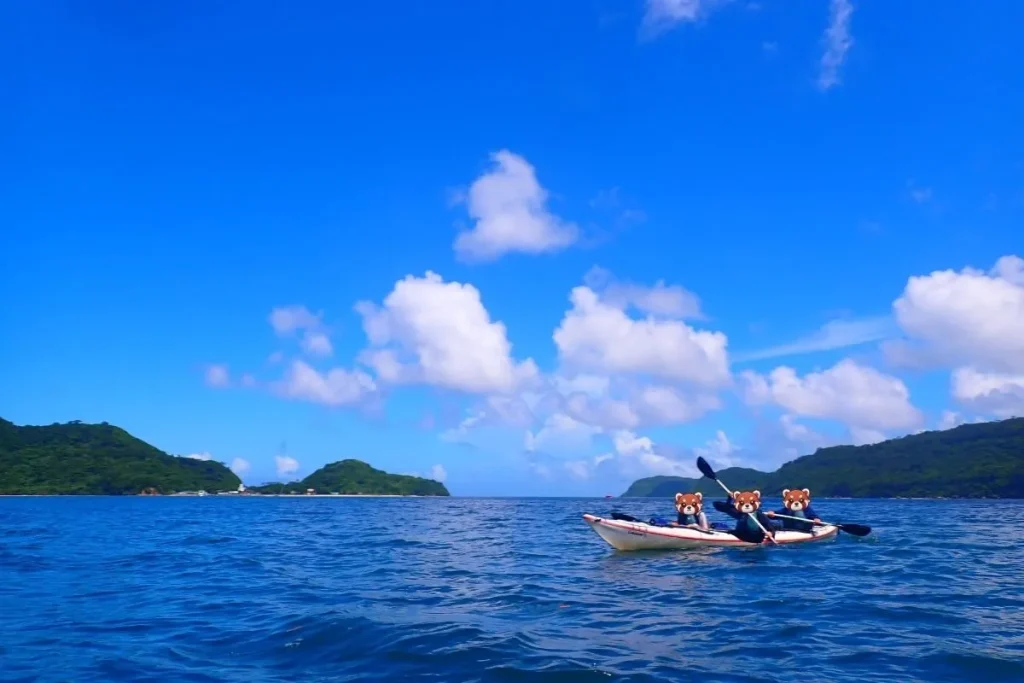Three-person kayak team on open water during our Iriomote kayaking tour.