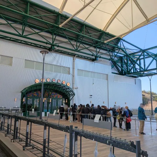 Guests lining up outside the Ghibli Park Grand Warehouse before opening, showing why early arrival is key to enjoying Narikiri Studio – practical tip for Ghibli Park Japan travel.
