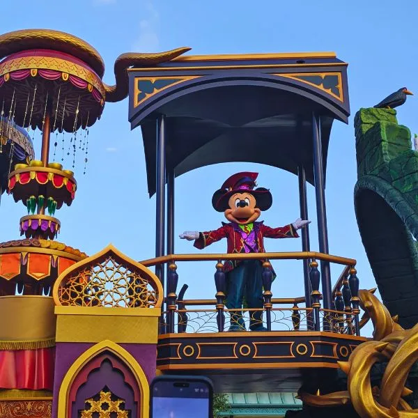 Mickey Mouse in Halloween costume waving from a parade float at Tokyo Disneyland Halloween Parade.
