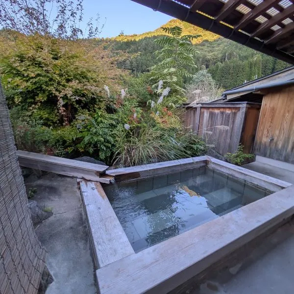 Private open-air wooden tub amid greenery at Okuhida onsen—relaxing family stop on a Kamikochi itinerary.