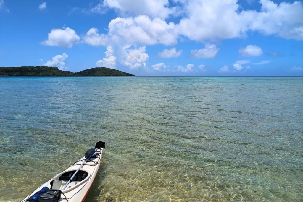 Calm clear sea and kayak at a tropical beach, showing the relaxed vibe of Okinawa family beach resorts for parents and children.